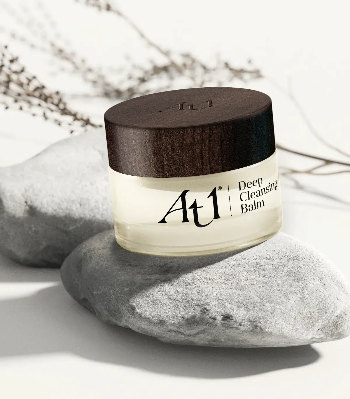 Deep cleansing balm tub shot. A circular glass tub with dark wood effect lid